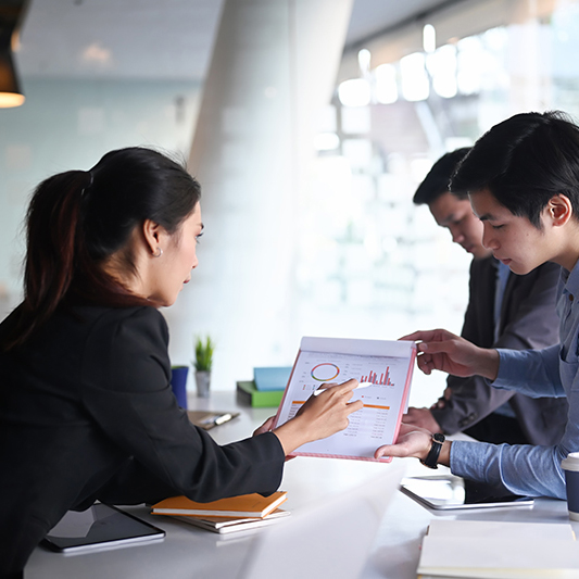 Business people analyzing documents and discussing business stra